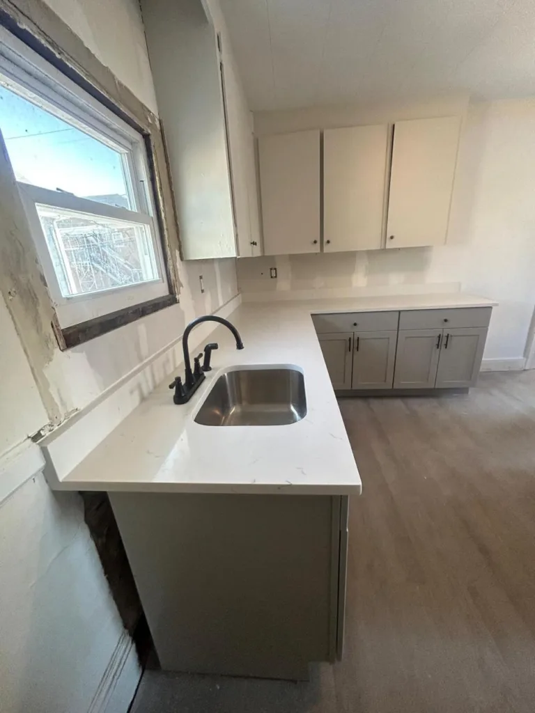 Close-up view of a Calacatta Carrara Quartz Installation in a Medford kitchen featuring an undermount sink and matte black faucet.