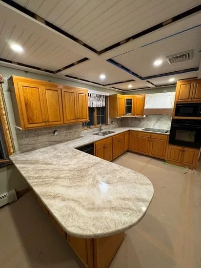 Custom asymmetrical rounded peninsula edge completed for a Taj Mahal Quartzite Kitchen project.